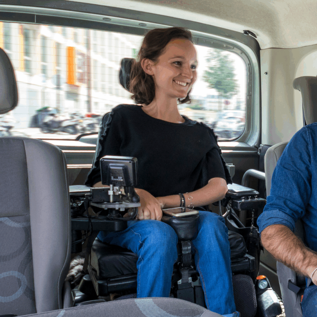 Photo de Charlotte souriante dans le coffre d'une voiture aménagée